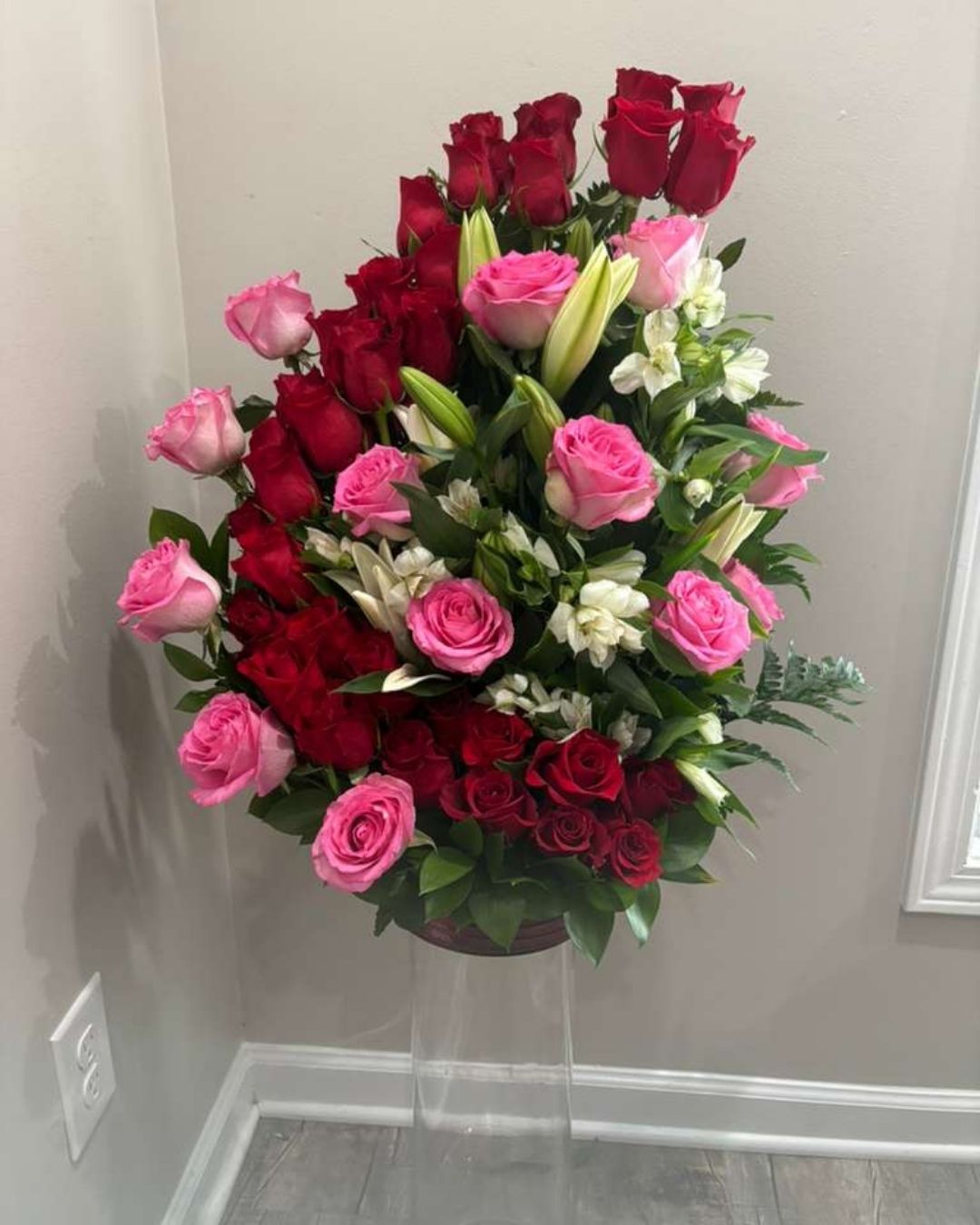JJJ Elegance floral arrangement with red roses, Tiffany accents, and lilies.