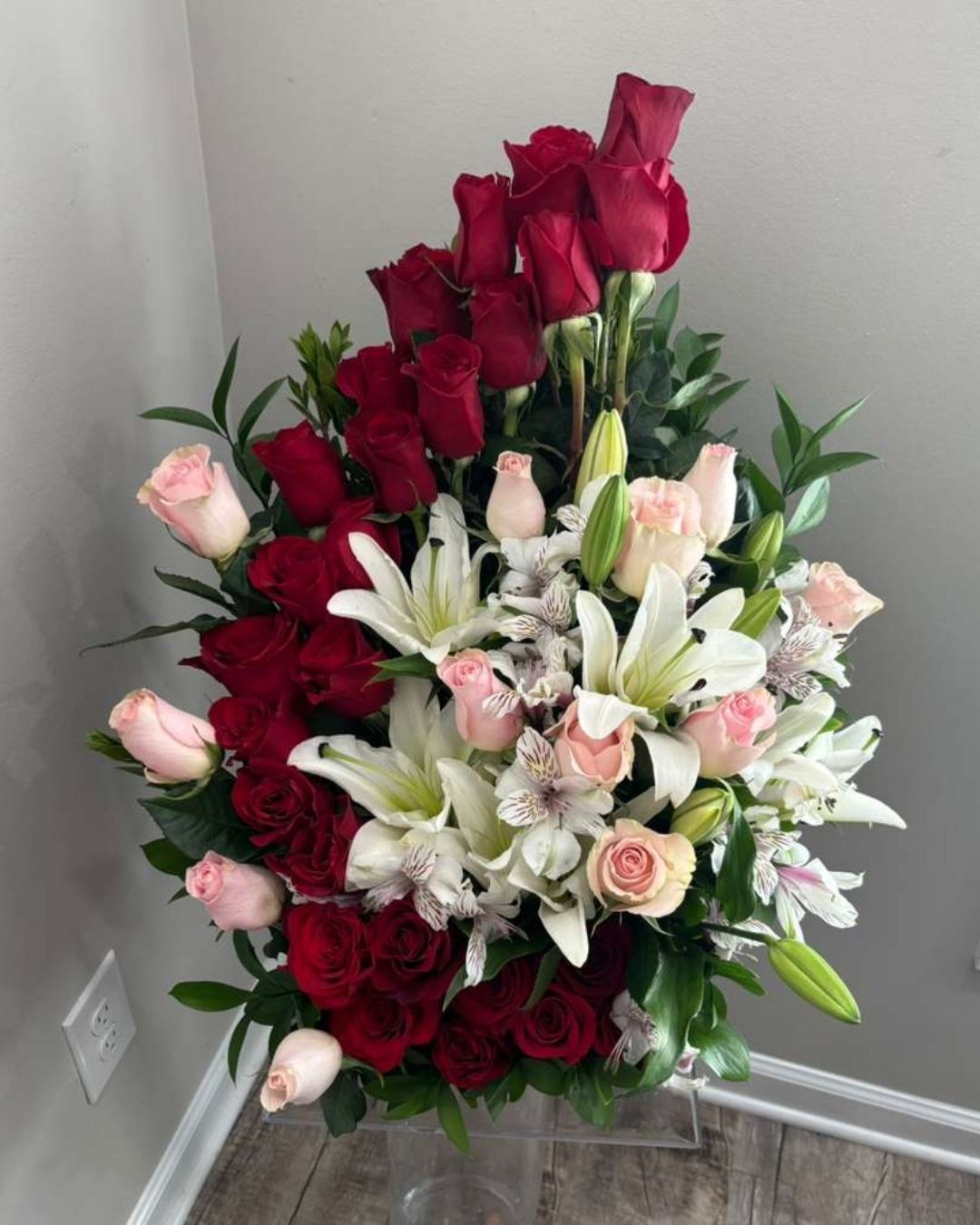 JJJ Romance floral arrangement with red and pink roses and lilies.