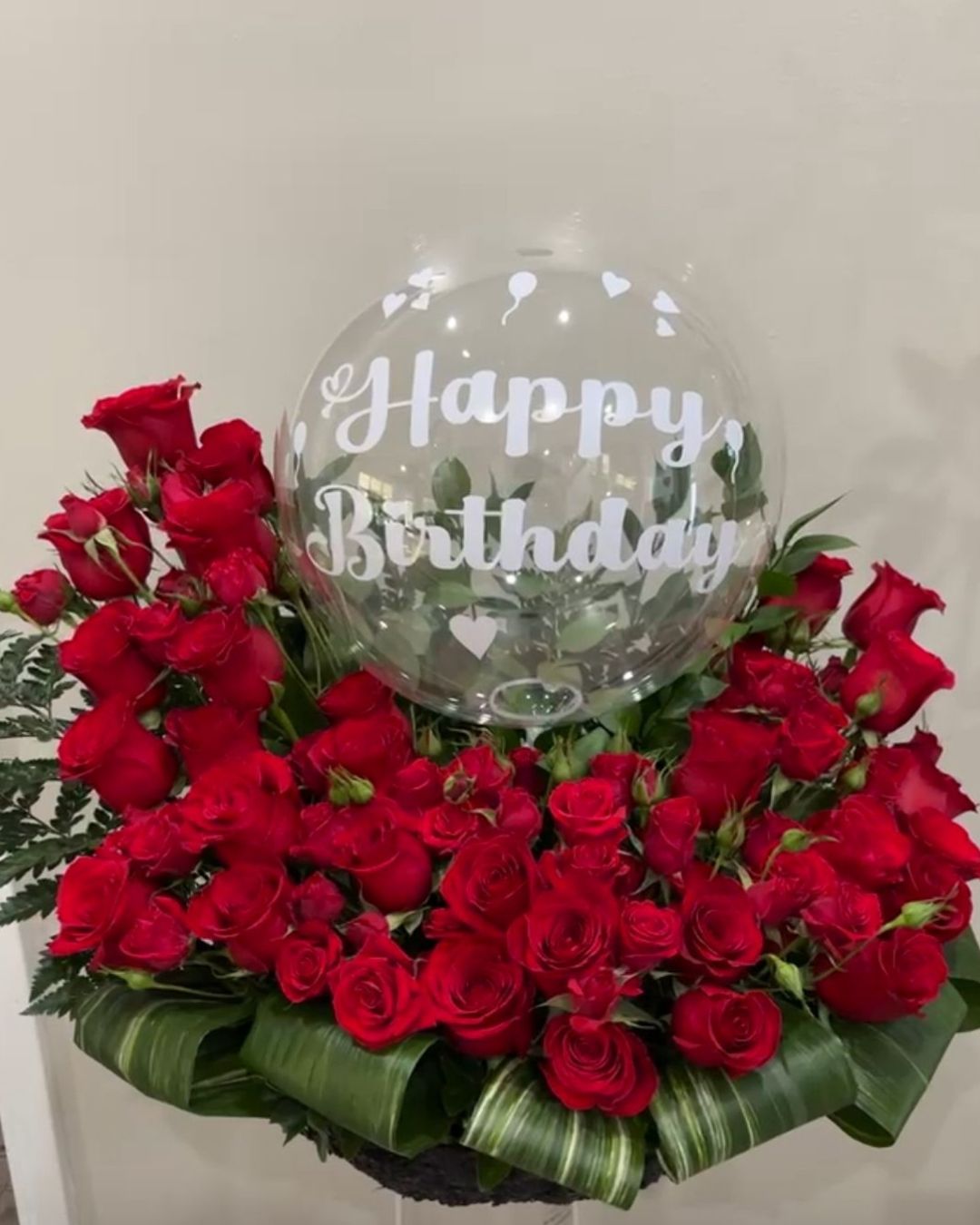 Kat red rose arrangement with a personalized balloon.