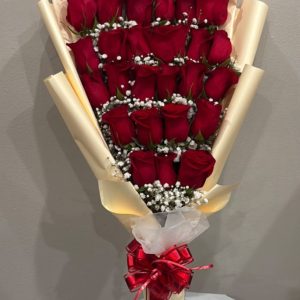 Baby Bouquet of 25 red roses with white filler flowers, gold-toned wrapping, and a red bow.