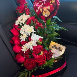 Your Smile arrangement with red roses, white flowers, greenery, chocolates, a heart-shaped balloon, and a note in a black box with red ribbon.